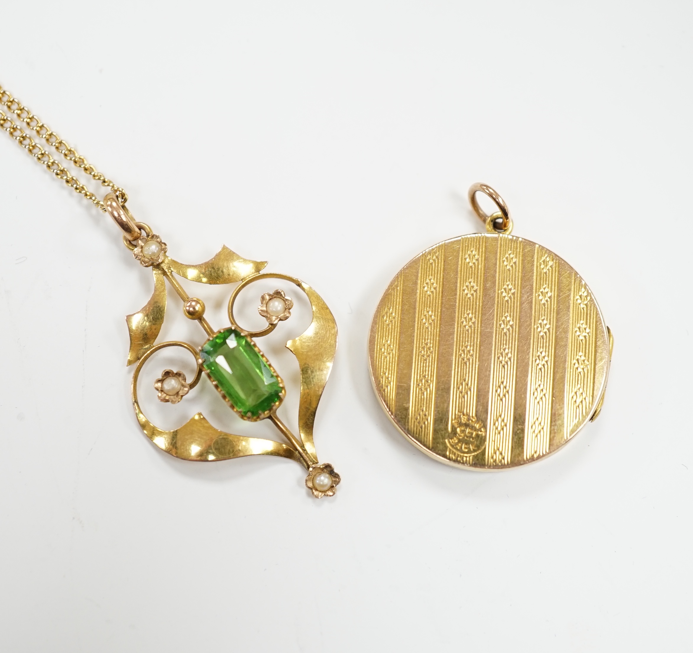 An Edwardian Art Nouveau 9ct, green tourmaline? and seed pearl set pendant, 37mm, on a gilt metal chain, together with a '9ct back and front' locket.